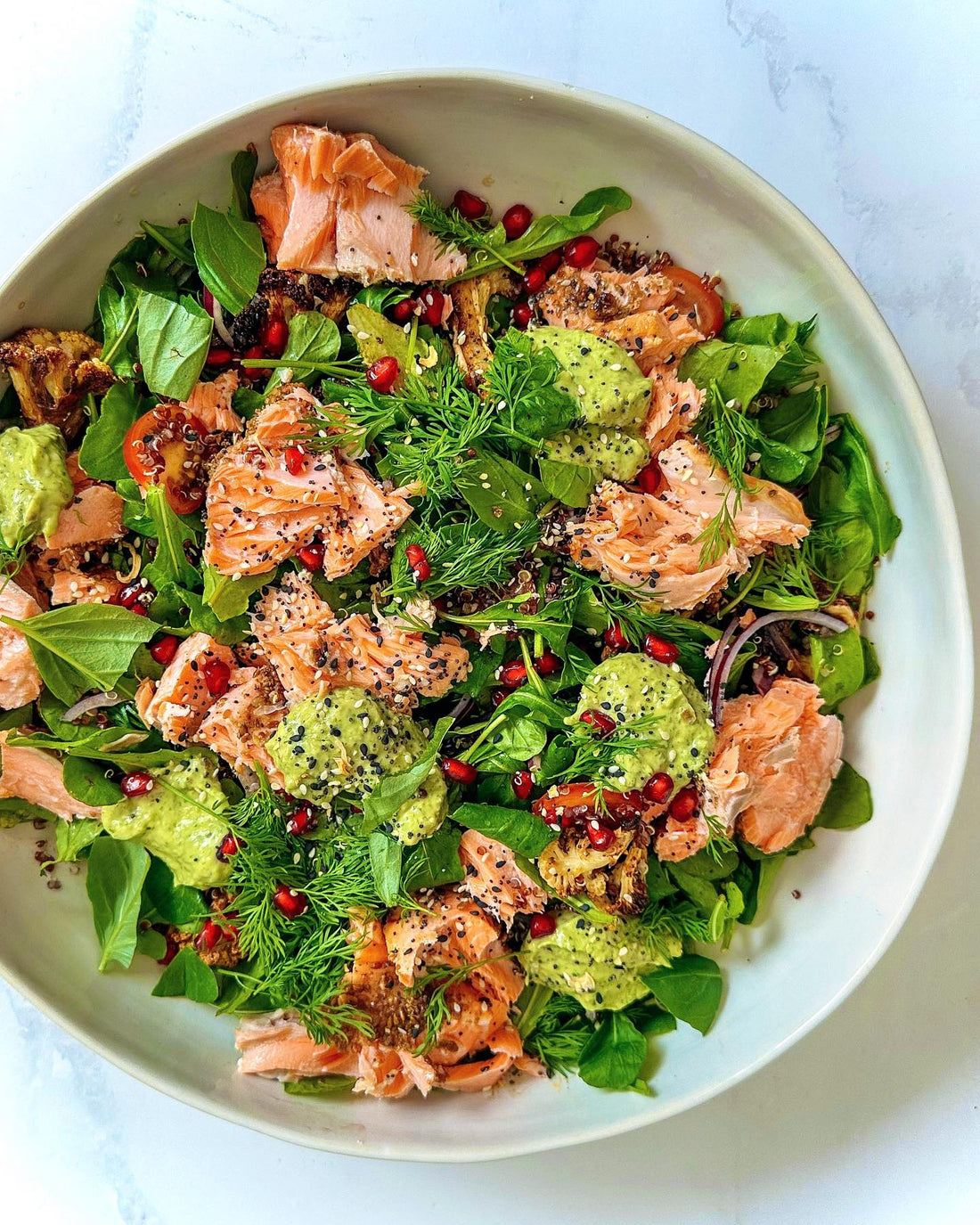 Baked salmon salad with quinoa, roasted cauliflower and an avocado crema